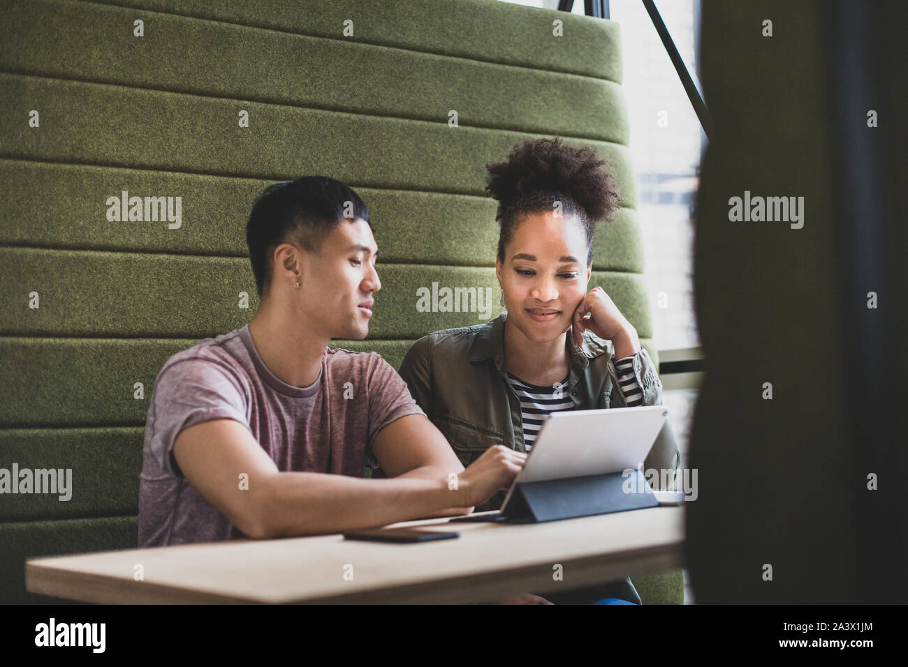 I colleghi di lavoro in occasione di un incontro guardando una tavoletta digitale Foto Stock