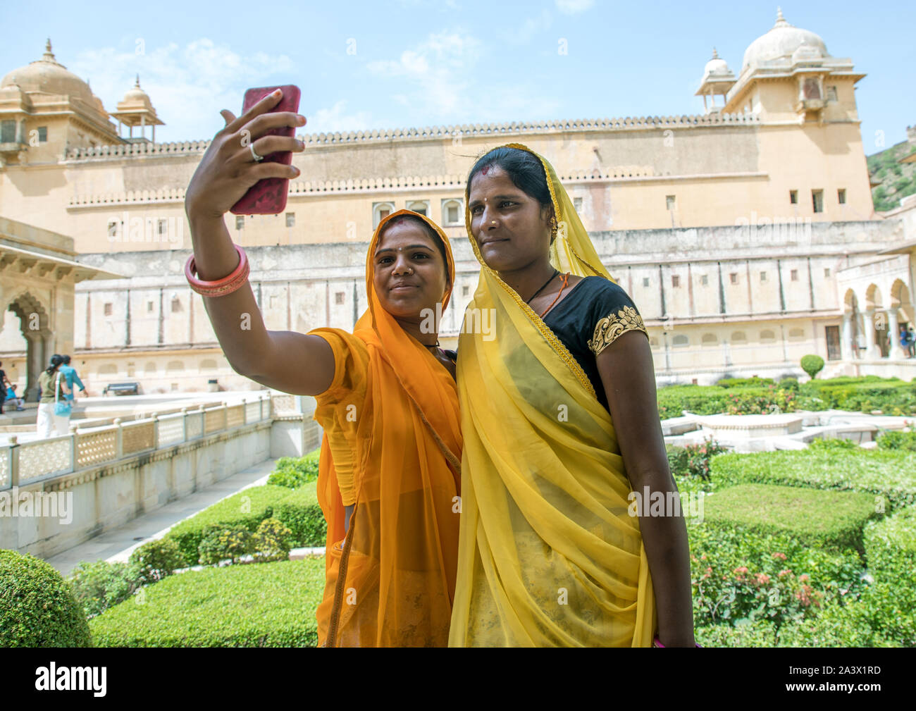 Le donne indiane prendendo selfie nella parte anteriore del Forte Amer e palazzo, Rajasthan, Amer, India Foto Stock