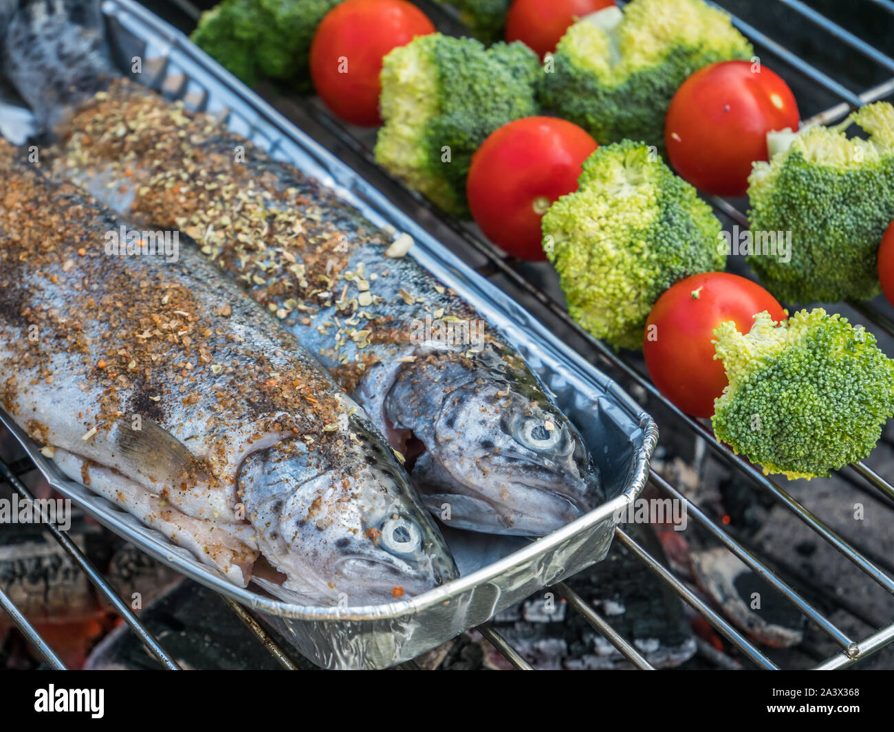 Fresca trota speziato con gli spiedini di vegetali Foto Stock
