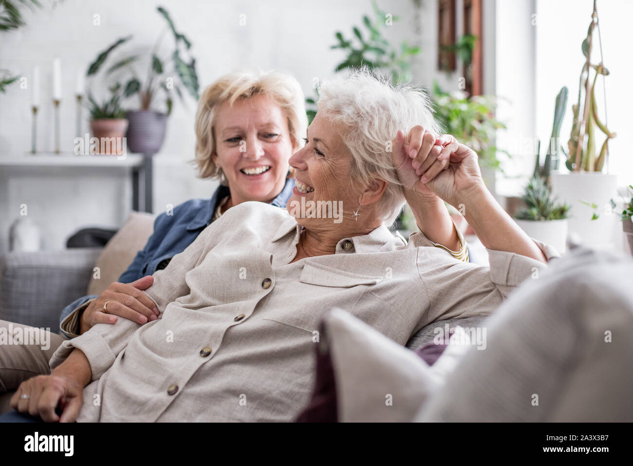 Coppia lesbica giovane a casa sul divano Foto Stock