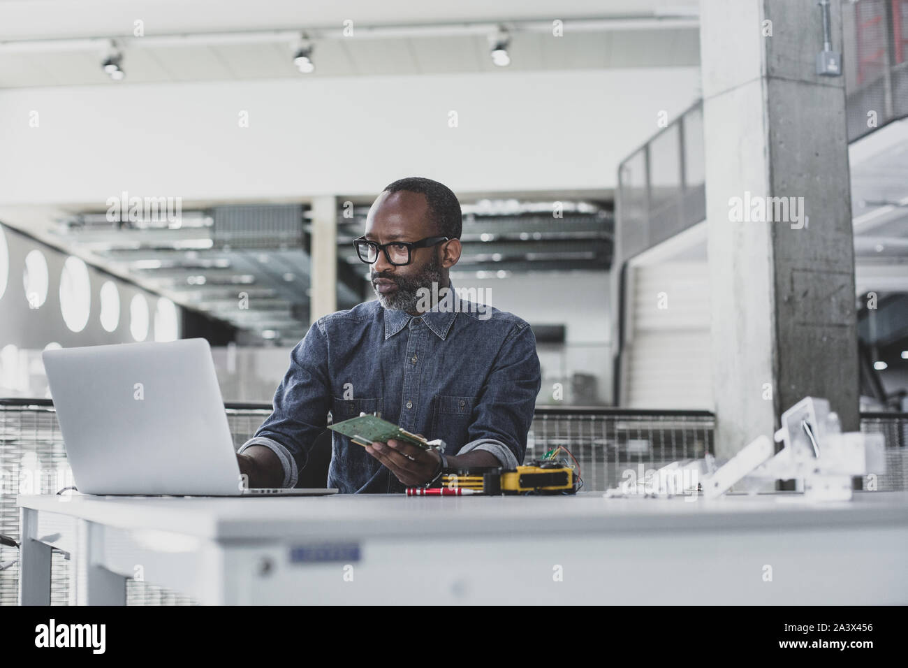 African American maschio adulto lavorando su robotica Foto Stock