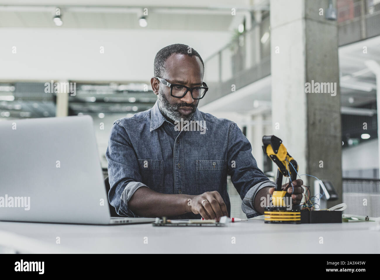 African American maschio adulto lavorando su robotica Foto Stock