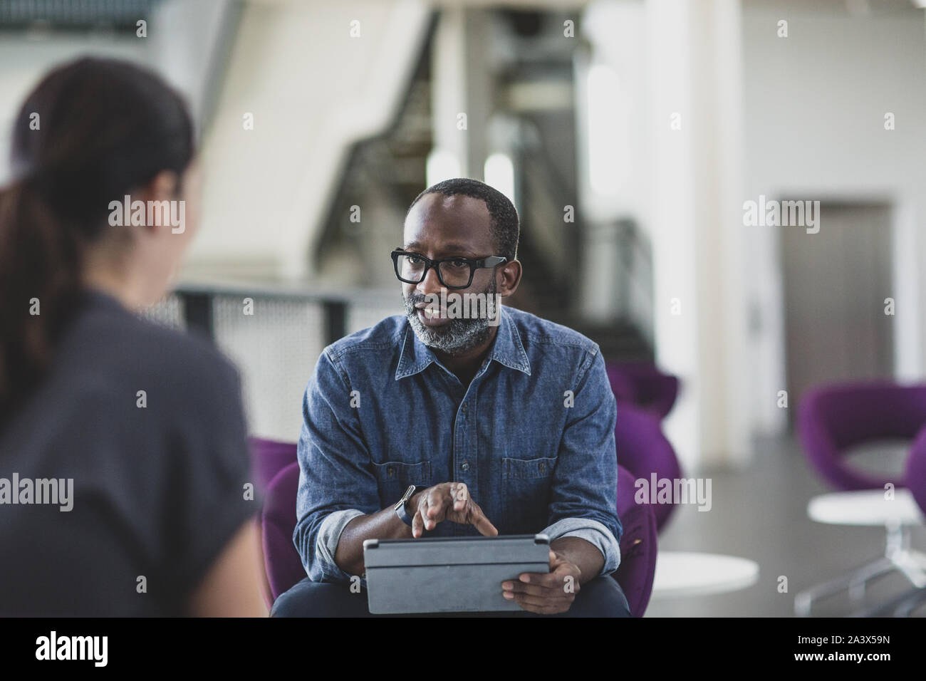 African American businessman utilizzando una tavoletta digitale in una riunione Foto Stock