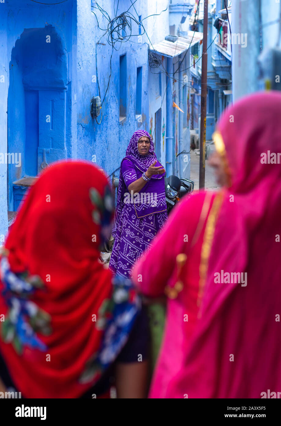 Rajasthani donne nella parte anteriore delle vecchie case blu, Rajasthan, Bundi, India Foto Stock