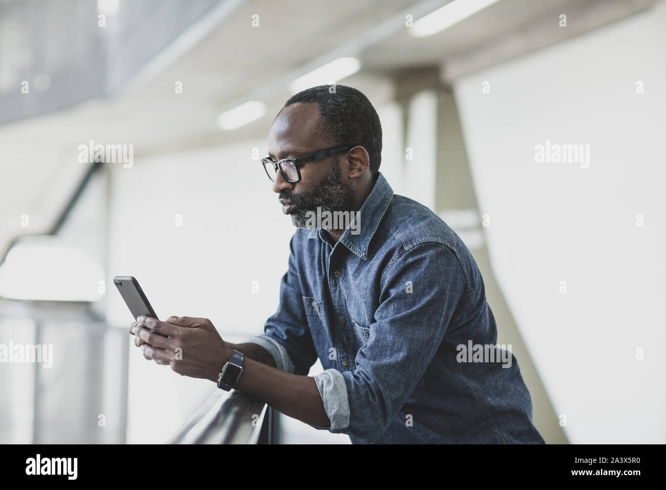 African American imprenditore utilizza lo smartphone Foto Stock