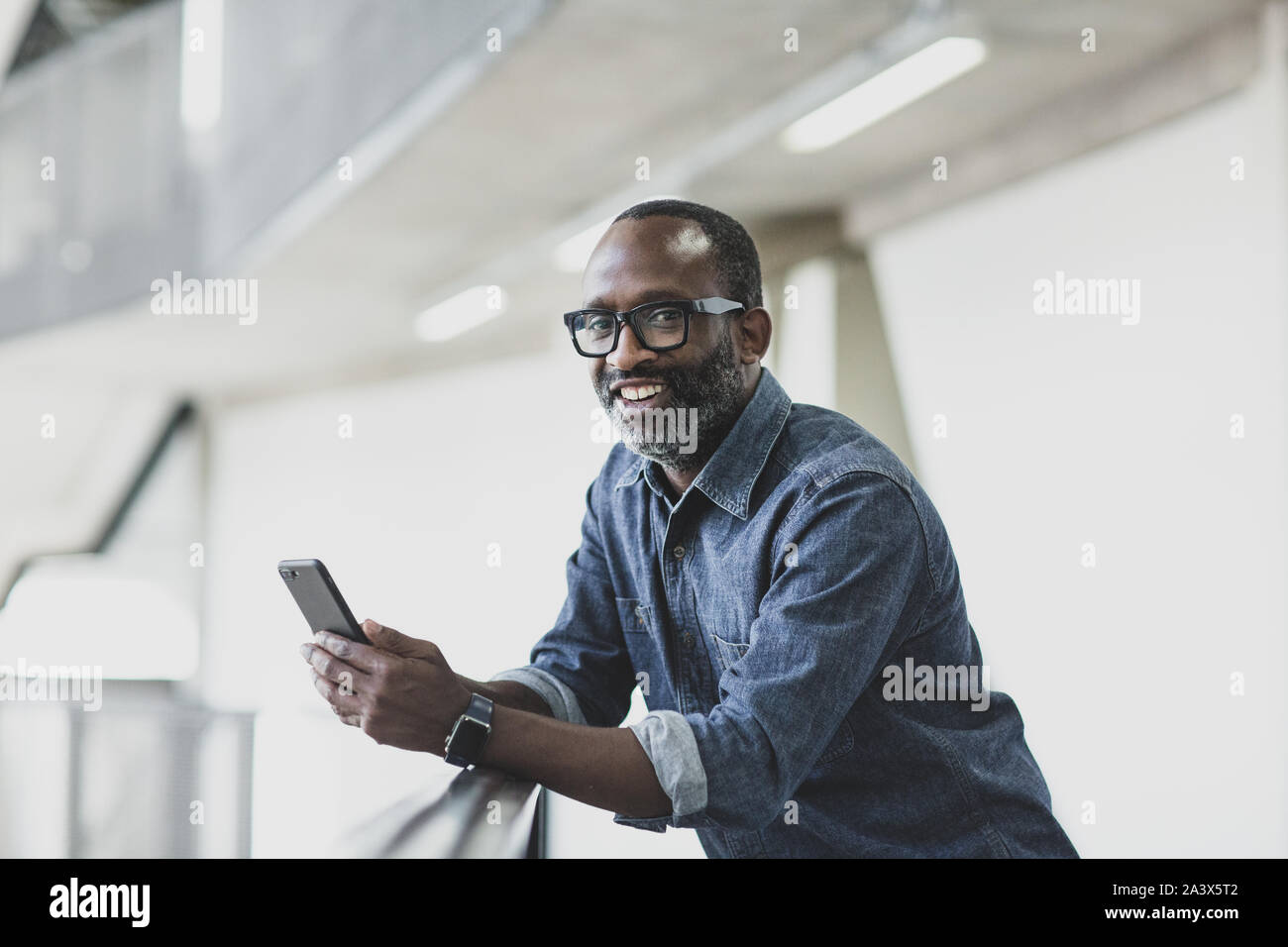 Ritratto di African American maschio azienda esecutivo uno smartphone Foto Stock