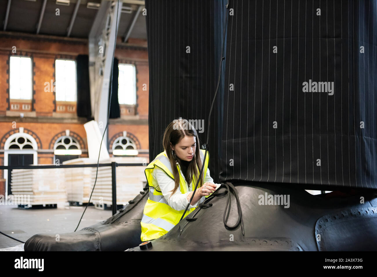 Una coppia di gambe gigante noto come '" clandestino misurare oltre dieci metri di altezza sono eretto all'Aviva Investors Manchester Art Fair al Manchester Central attraverso 11-13Ottobre 2019. Le gambe sono il lavoro di 23 anno vecchio Manchester Scuola d'arte laureato Millie Sansom. L'installazione è costituito da tessuto, polistirene e similpelle e dimostra lo squilibrio di potere tra cittadini e politici o di imprese "giganti". Foto Stock