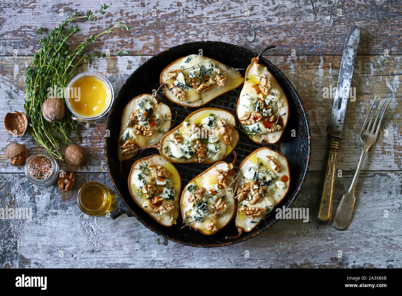 Pere al forno con formaggio blu, di miele e di erbe aromatiche. Cucina francese antipasto al vino. Messa a fuoco selettiva. Macro. Foto Stock