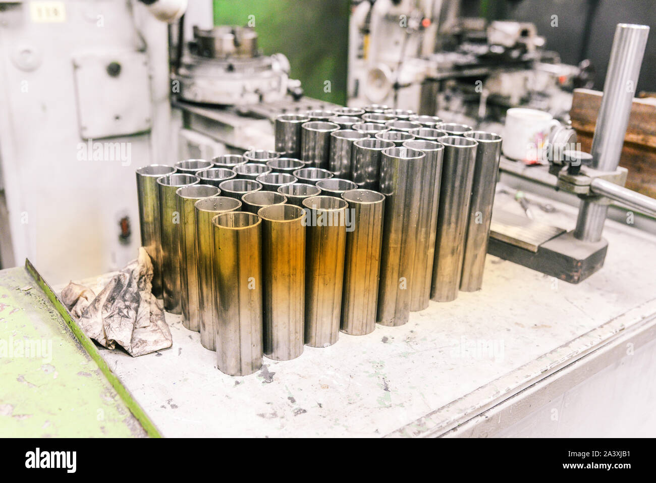 Tubi in acciaio di varie forme nell'industria metallurgica. Le parti cromate prodotte in fabbrica. Il posto di lavoro di un dipendente di un settore industriale e Foto Stock