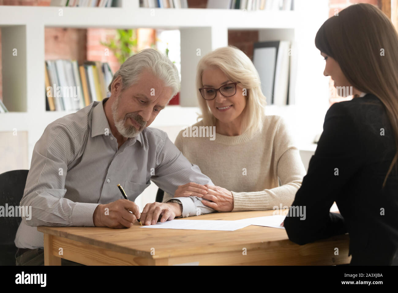 Felice clienti maturi firmano il contratto chiusura trattativa con il banchiere Foto Stock