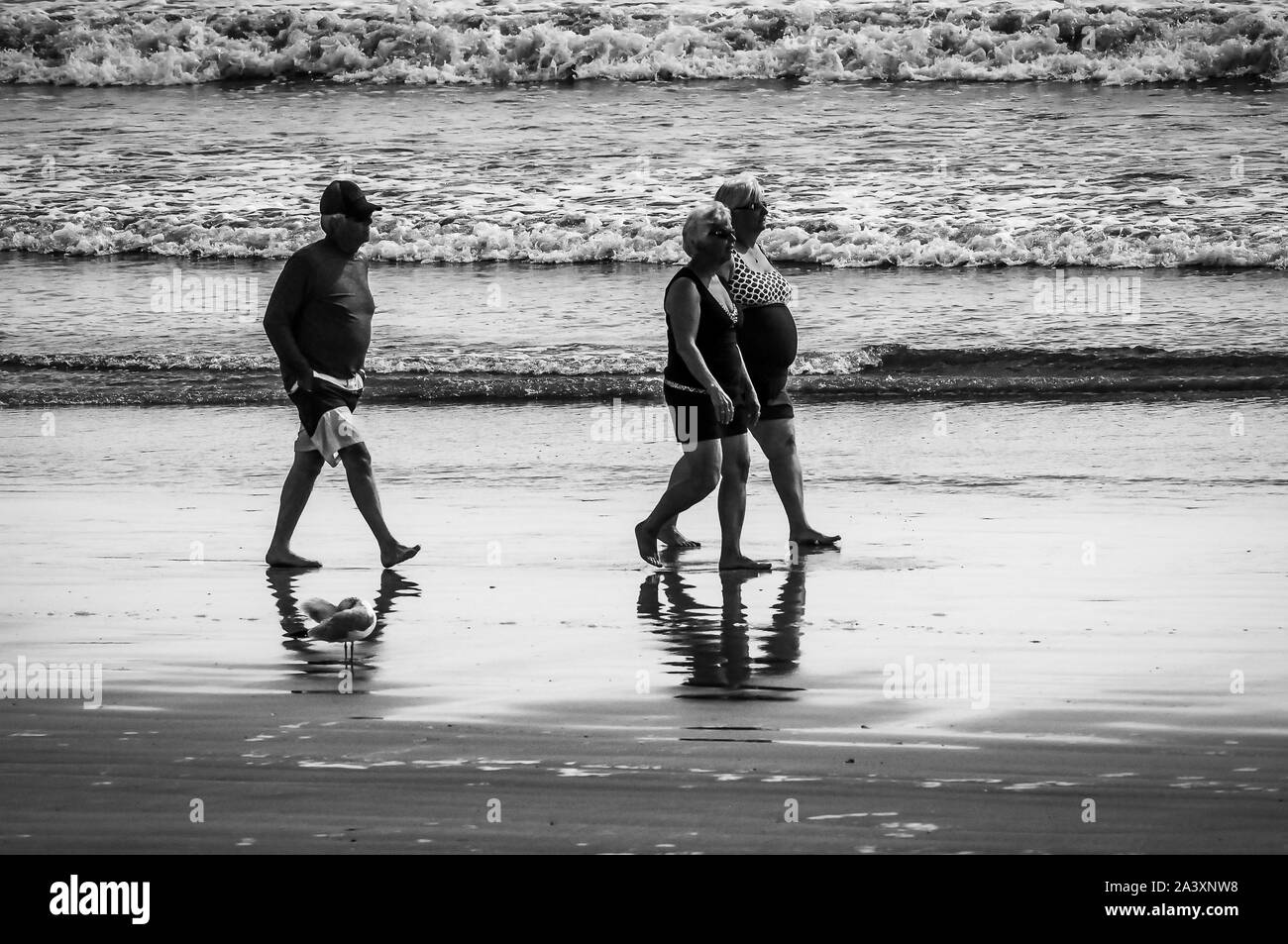 Queste persone fuori per un inizio di camminare sulla spiaggia godendosi gli ultimi giorni caldi di estate. Ma uno di loro kept falling dietro, e detto di tenere per mantenere . Foto Stock