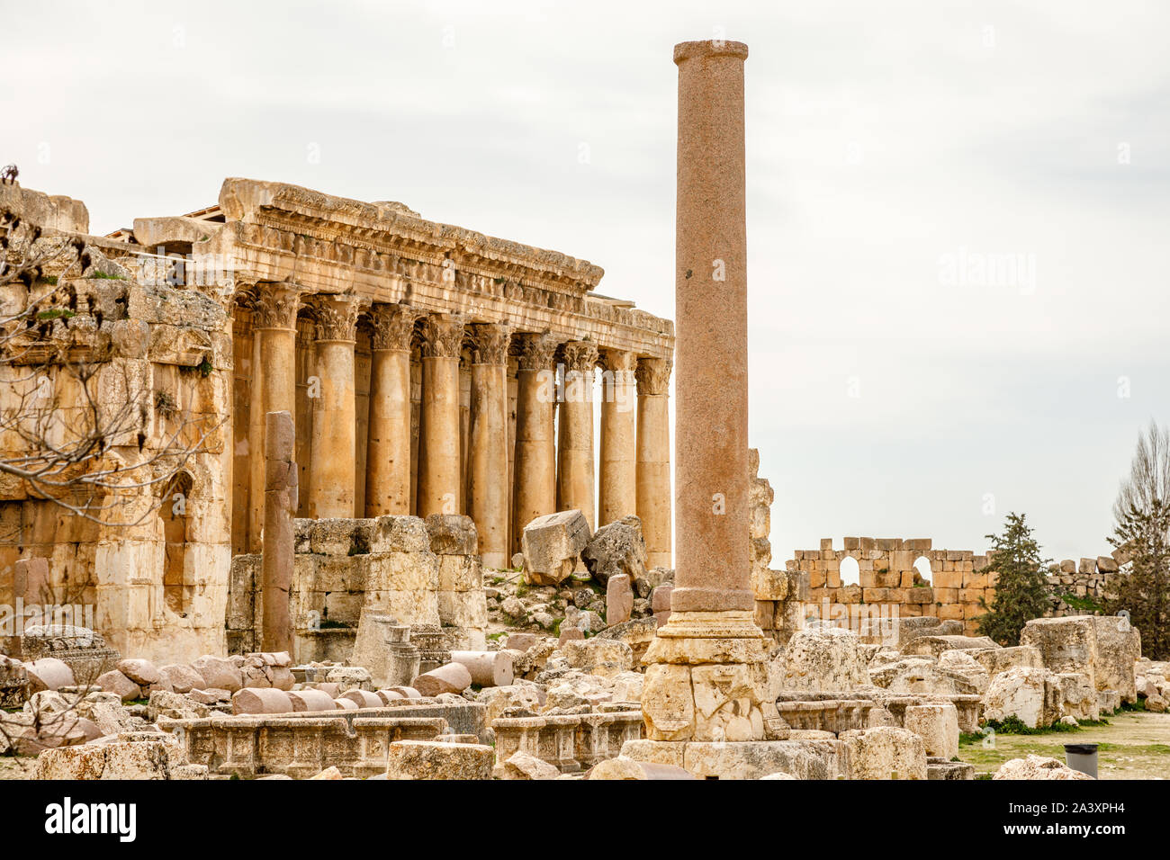 Antico tempio romano di Bacco e colonna in primo piano con rovine circostanti della città antica, Bekaa Valley, Baalbek, Libano Foto Stock