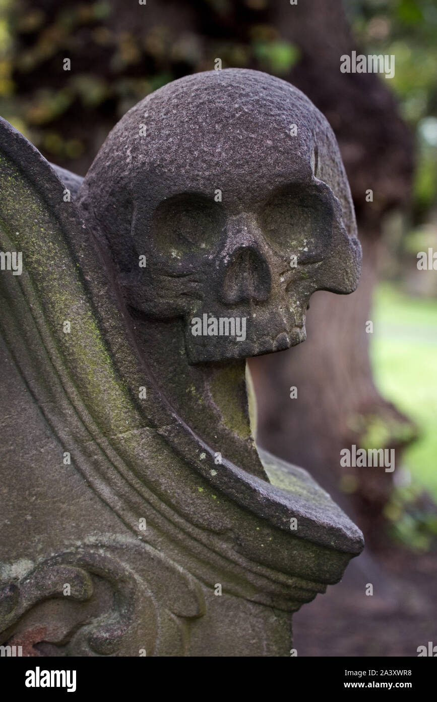 Memento Mori, cranio su una lapide in St Cuthbert's sagrato, Edimburgo, Scozia, Regno Unito. Foto Stock