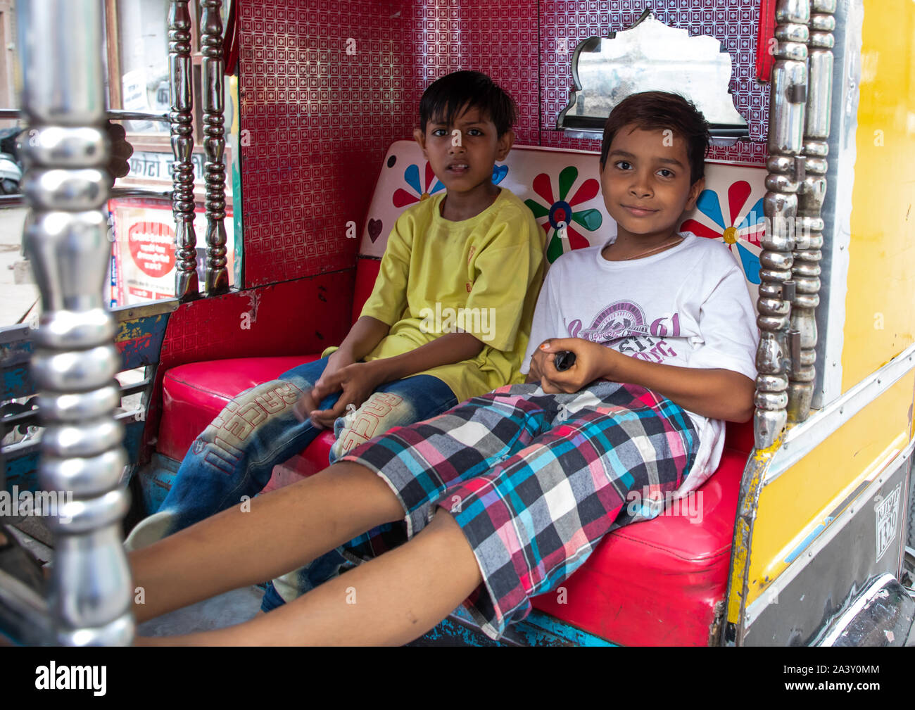 Due ragazzi indiani a sedersi in un rickshaw, Rajasthan, Jodhpur, India Foto Stock
