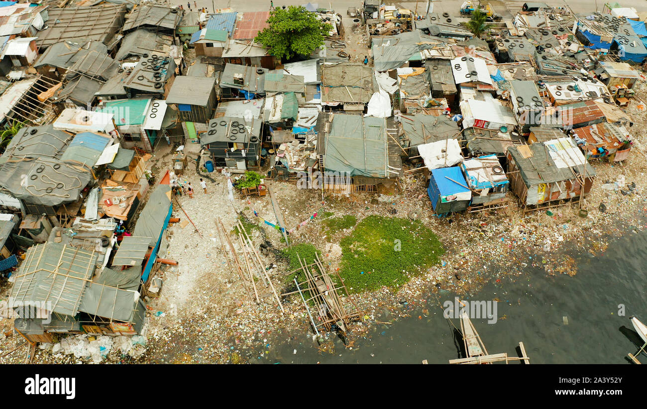 Baraccopoli di Manila vicino al porto. Fiume inquinato con plastica e spazzatura. Manila, Filippine. Foto Stock