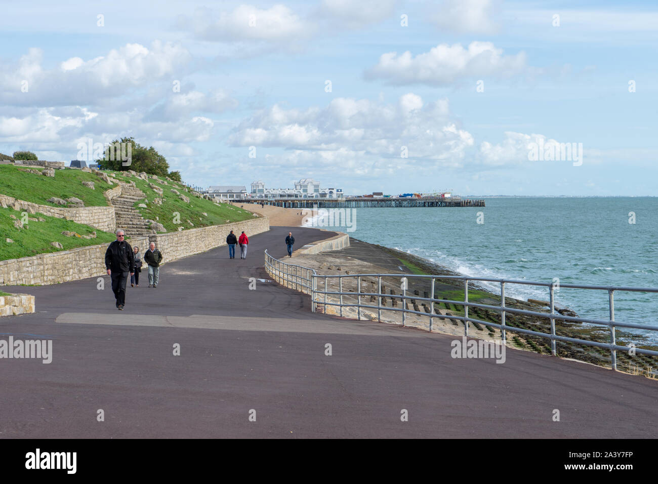 La gente camminare lungo la spiaggia a Southsea Portsmouth con South Parade pier in background Foto Stock