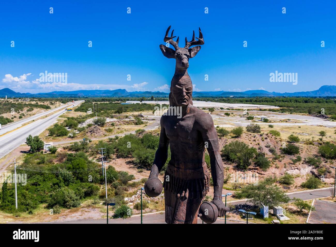 Gigantesca statua di ballo Yaqui o la danza del cervo indigena il gruppo etnico di Sonora in Messico. Trubu Yaqui. Le corna di cervo. La scultura è di oltre trenta metri di altezza ed è situato nella località turistica stop sul Messico 15 Road, accanto alla valle Yaqui. Yaqui gruppo etnico. Tribù Yaqui, tribù, indigeni, cervi ballerino. Deer Dance. Avvisatore acustico. Parador dispone di un quadrato, fontana, un area cerimoniale e di deserto giardinaggio con mesquite, ironwood e greenwood. © (© Foto: LuisGutierrez / NortePhoto.com) Estatua gigante de danzante Yaqui de la etnia más representativa en el estado de Sonora, Messico. La escultura mide más d Foto Stock