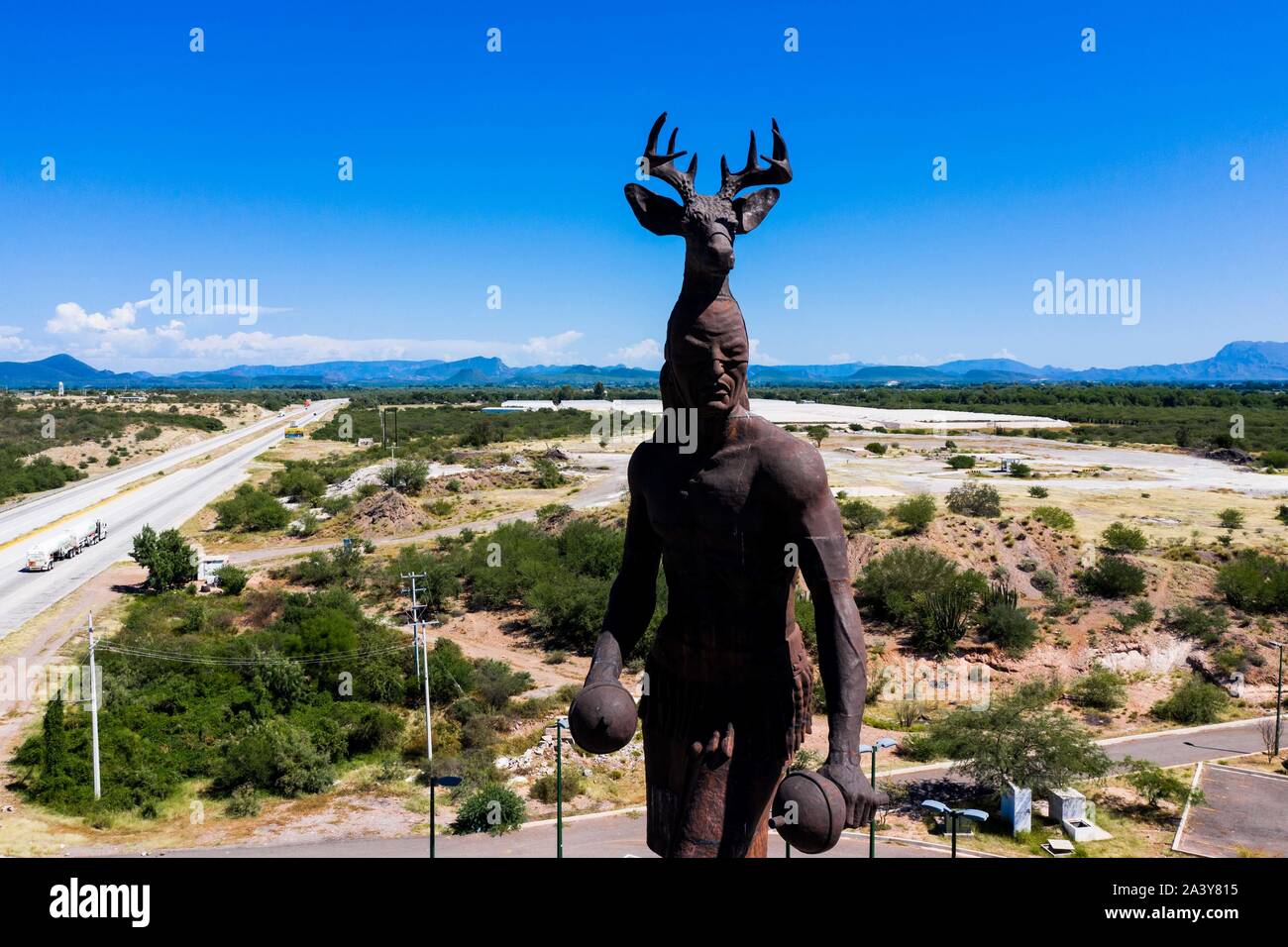Gigantesca statua di ballo Yaqui o la danza del cervo indigena il gruppo etnico di Sonora in Messico. Trubu Yaqui. Le corna di cervo. La scultura è di oltre trenta metri di altezza ed è situato nella località turistica stop sul Messico 15 Road, accanto alla valle Yaqui. Yaqui gruppo etnico. Tribù Yaqui, tribù, indigeni, cervi ballerino. Deer Dance. Avvisatore acustico. Parador dispone di un quadrato, fontana, un area cerimoniale e di deserto giardinaggio con mesquite, ironwood e greenwood. © (© Foto: LuisGutierrez / NortePhoto.com) Estatua gigante de danzante Yaqui de la etnia más representativa en el estado de Sonora, Messico. La escultura mide más d Foto Stock
