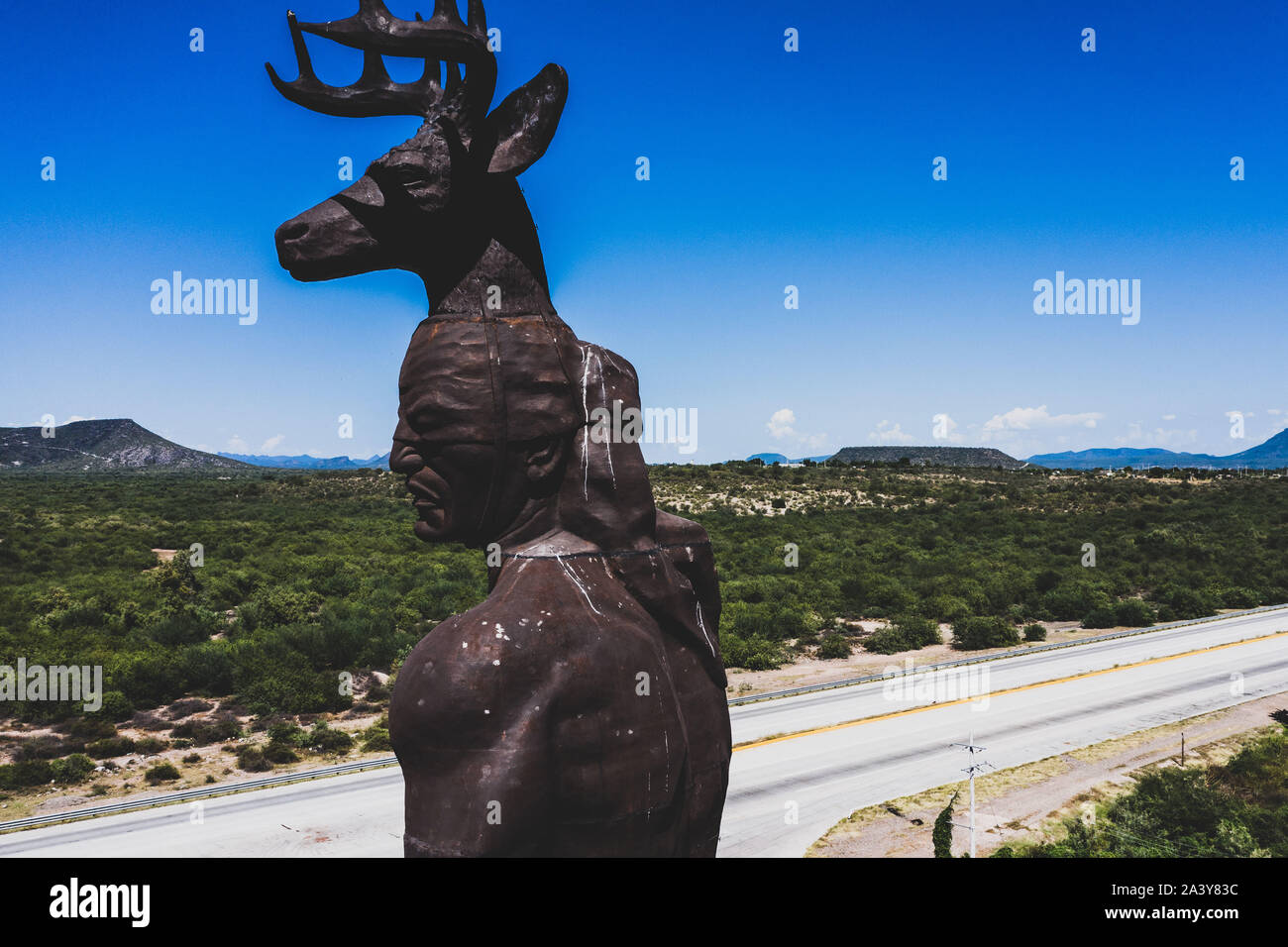 Gigantesca statua di ballo Yaqui o la danza del cervo indigena il gruppo etnico di Sonora in Messico. Trubu Yaqui. Le corna di cervo. La scultura è di oltre trenta metri di altezza ed è situato nella località turistica stop sul Messico 15 Road, accanto alla valle Yaqui. Yaqui gruppo etnico. Tribù Yaqui, tribù, indigeni, cervi ballerino. Deer Dance. Avvisatore acustico. Parador dispone di un quadrato, fontana, un area cerimoniale e di deserto giardinaggio con mesquite, ironwood e greenwood. © (© Foto: LuisGutierrez / NortePhoto.com) Estatua gigante de danzante Yaqui de la etnia más representativa en el estado de Sonora, Messico. La escultura mide más d Foto Stock