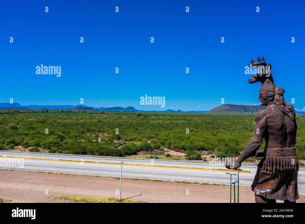 Gigantesca statua di ballo Yaqui o la danza del cervo indigena il gruppo etnico di Sonora in Messico. Trubu Yaqui. Le corna di cervo. La scultura è di oltre trenta metri di altezza ed è situato nella località turistica stop sul Messico 15 Road, accanto alla valle Yaqui. Yaqui gruppo etnico. Tribù Yaqui, tribù, indigeni, cervi ballerino. Deer Dance. Avvisatore acustico. Parador dispone di un quadrato, fontana, un area cerimoniale e di deserto giardinaggio con mesquite, ironwood e greenwood. © (© Foto: LuisGutierrez / NortePhoto.com) Estatua gigante de danzante Yaqui de la etnia más representativa en el estado de Sonora, Messico. La escultura mide más d Foto Stock