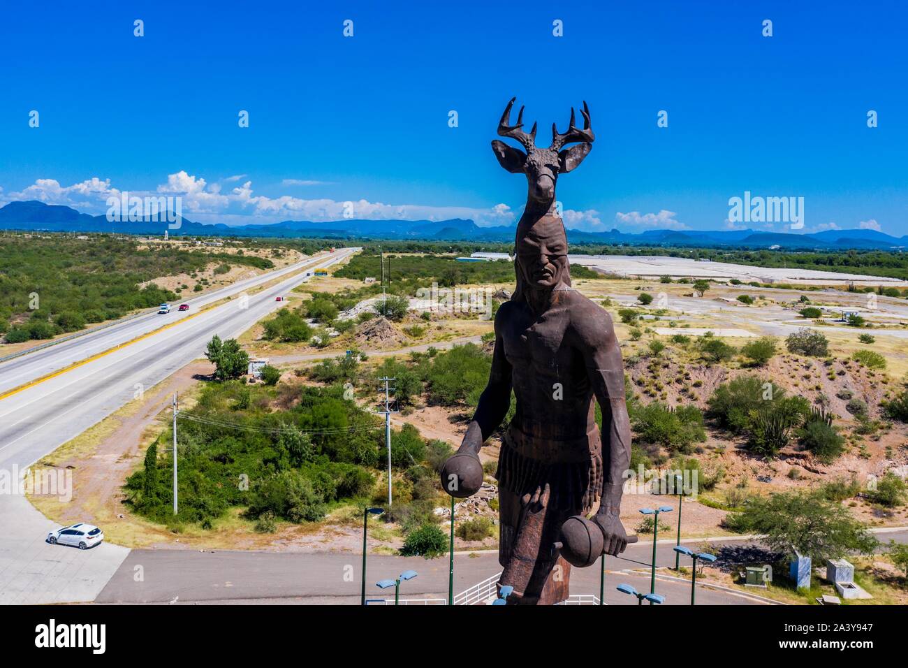Gigantesca statua di ballo Yaqui o la danza del cervo indigena il gruppo etnico di Sonora in Messico. Trubu Yaqui. Le corna di cervo. La scultura è di oltre trenta metri di altezza ed è situato nella località turistica stop sul Messico 15 Road, accanto alla valle Yaqui. Yaqui gruppo etnico. Tribù Yaqui, tribù, indigeni, cervi ballerino. Deer Dance. Avvisatore acustico. Parador dispone di un quadrato, fontana, un area cerimoniale e di deserto giardinaggio con mesquite, ironwood e greenwood. © (© Foto: LuisGutierrez / NortePhoto.com) Estatua gigante de danzante Yaqui de la etnia más representativa en el estado de Sonora, Messico. La escultura mide más d Foto Stock