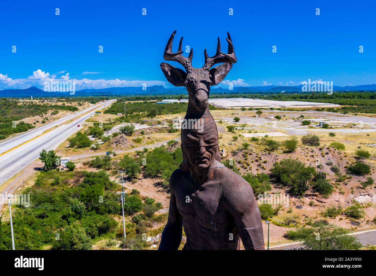 Gigantesca statua di ballo Yaqui o la danza del cervo indigena il gruppo etnico di Sonora in Messico. Trubu Yaqui. Le corna di cervo. La scultura è di oltre trenta metri di altezza ed è situato nella località turistica stop sul Messico 15 Road, accanto alla valle Yaqui. Yaqui gruppo etnico. Tribù Yaqui, tribù, indigeni, cervi ballerino. Deer Dance. Avvisatore acustico. Parador dispone di un quadrato, fontana, un area cerimoniale e di deserto giardinaggio con mesquite, ironwood e greenwood. © (© Foto: LuisGutierrez / NortePhoto.com) Estatua gigante de danzante Yaqui de la etnia más representativa en el estado de Sonora, Messico. La escultura mide más d Foto Stock