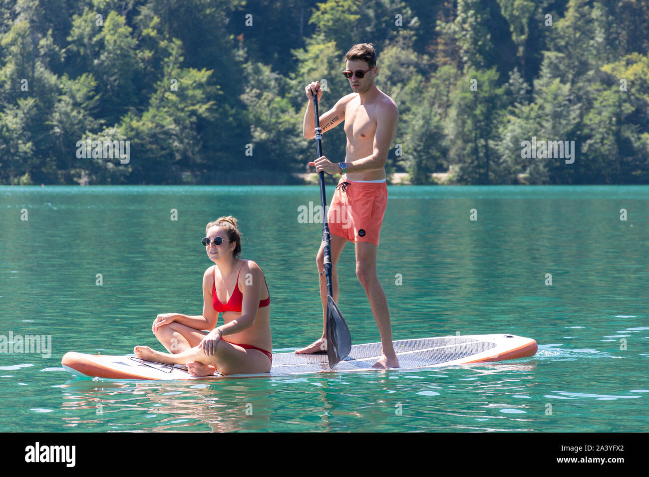 Coppia giovane paddleboarding vicino a Bled Island, il lago di Bled Bled, Alta Carniola Regione, Slovenia Foto Stock
