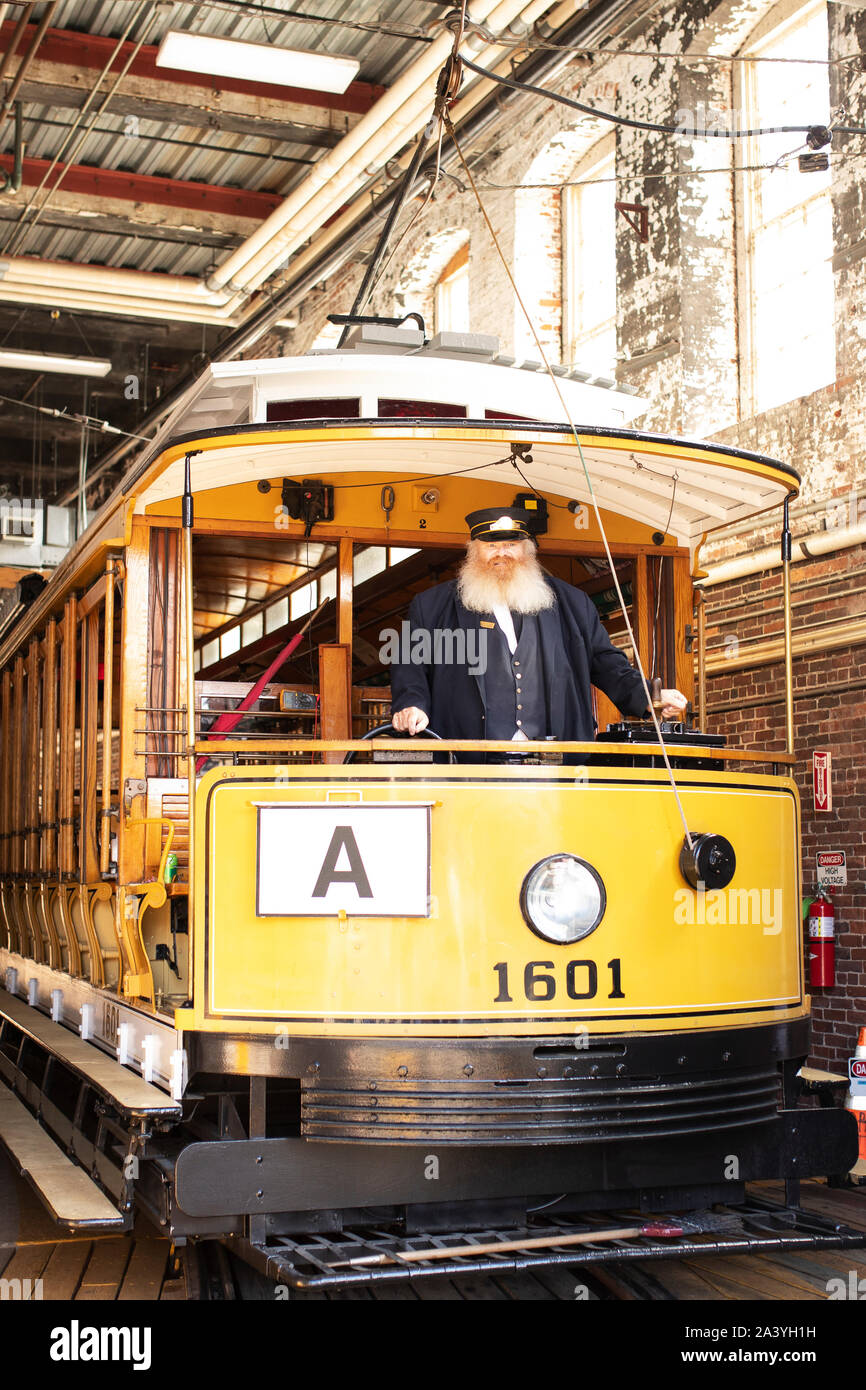 Un conduttore pone con un Tramvai storici auto nel garage del treno off Amory Street a Lowell, Massachusetts, STATI UNITI D'AMERICA. Foto Stock