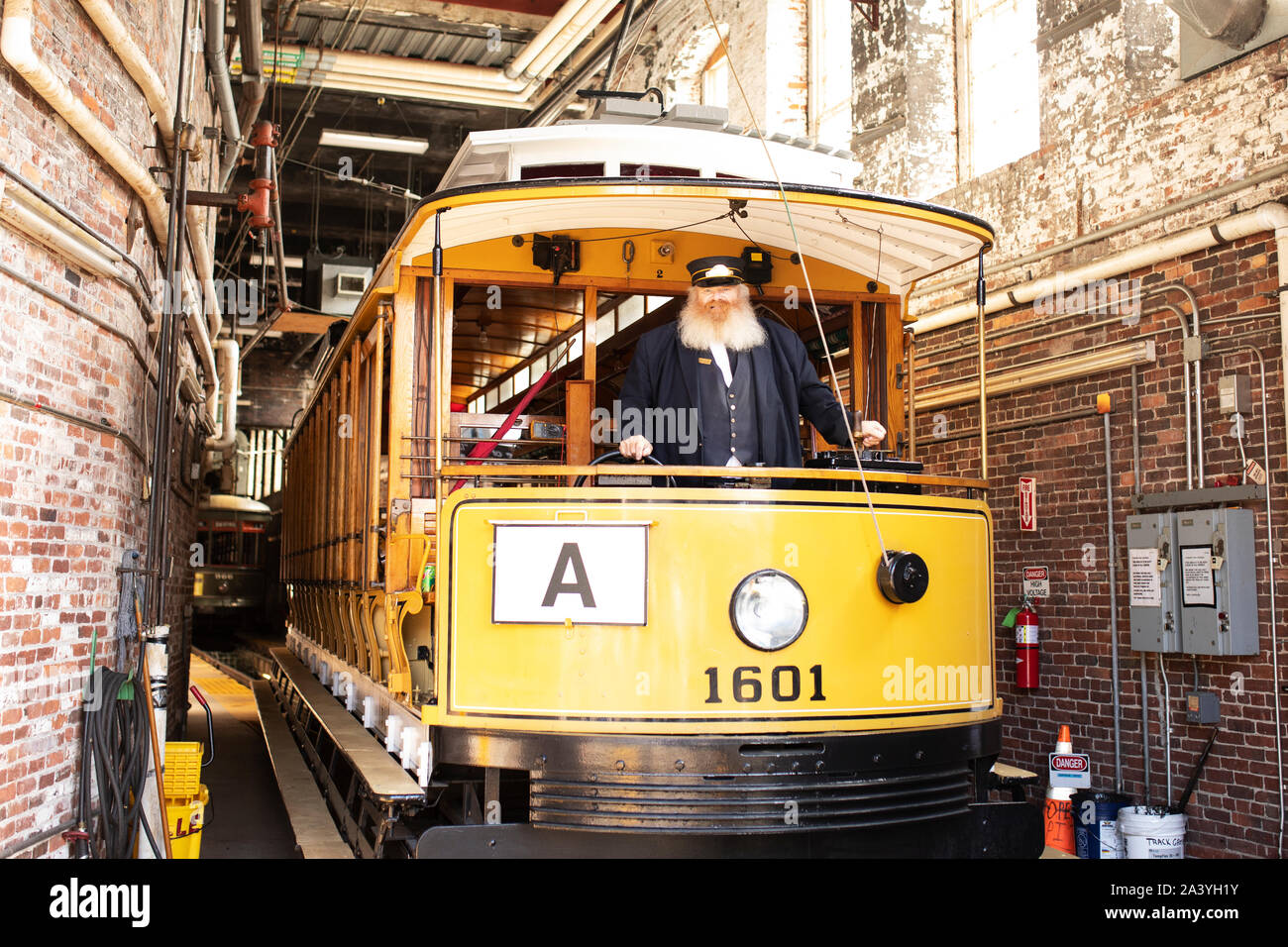 Un conduttore pone con un Tramvai storici auto nel garage del treno off Amory Street a Lowell, Massachusetts, STATI UNITI D'AMERICA. Foto Stock