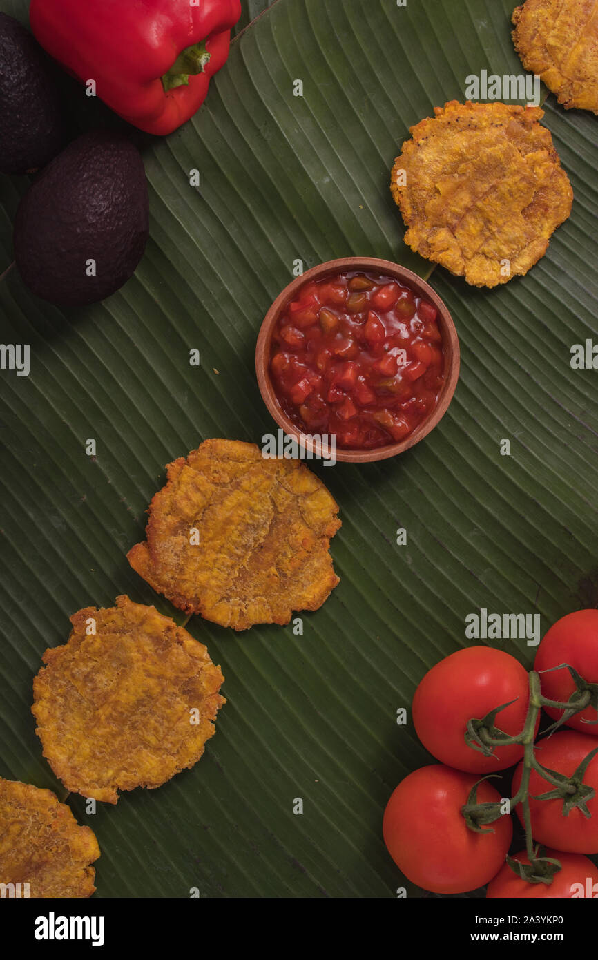 Fritte frittelle di banana su foglie di banano con chutney di pomodoro (rustico) Foto Stock