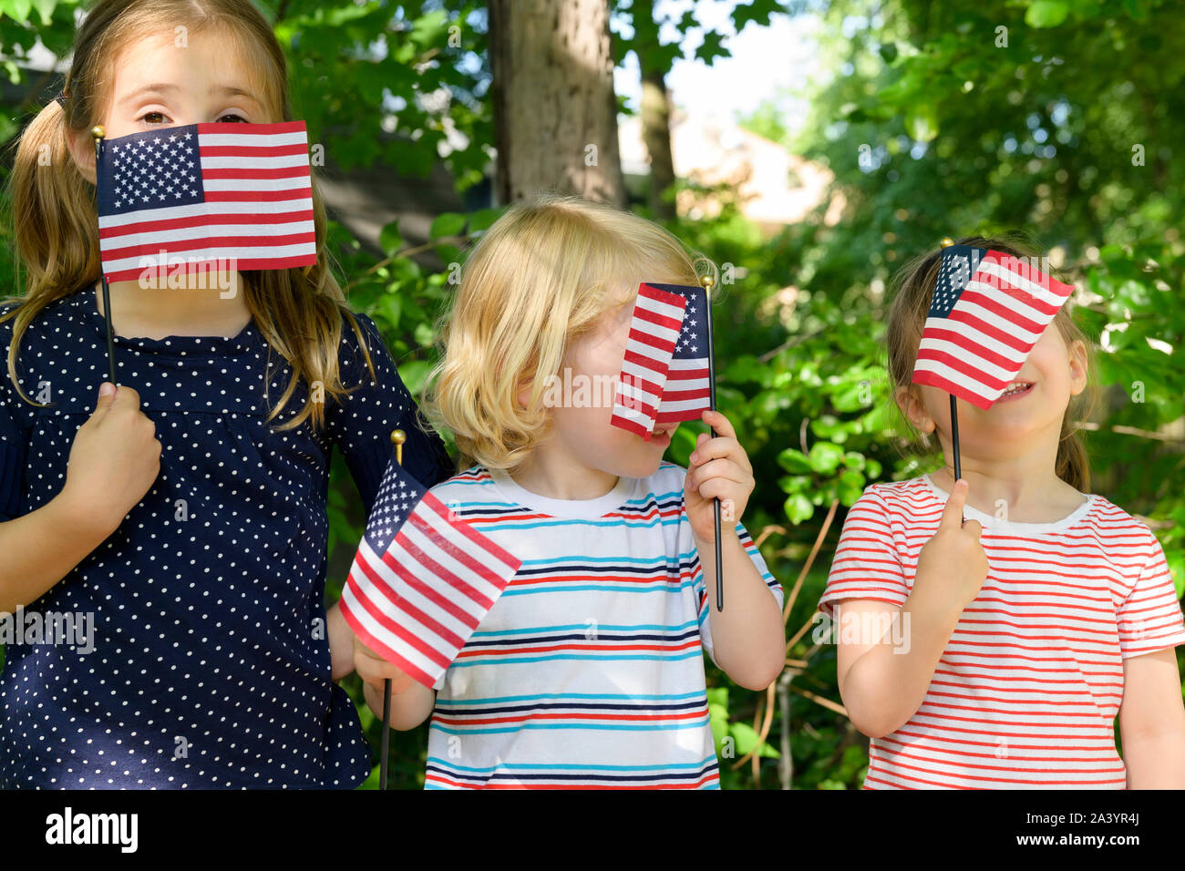 I bambini tenendo bandierine americane le loro facce Foto Stock