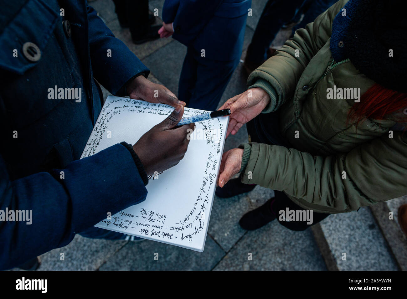 Un uomo scrive il suo nome in una tela a sostegno delle vittime durante il mese di marzo.Dopo due persone sono state uccise da un bandito che tenti di entrare in una sinagoga a est della città tedesca di Halle è stato un rally programmati in Colonia. Centinaia di persone si sono radunate intorno alla cattedrale di Colonia per mostrare il loro supporto in solidarietà con la comunità degli ebrei in Halle e ovunque. Il rally è stato organizzato dalla Germania due partiti politici e Deutsch-Israelische Gesellschaft (DIG), un gruppo di lavoro dell'Associazione federale delle società German-Israeli. Foto Stock