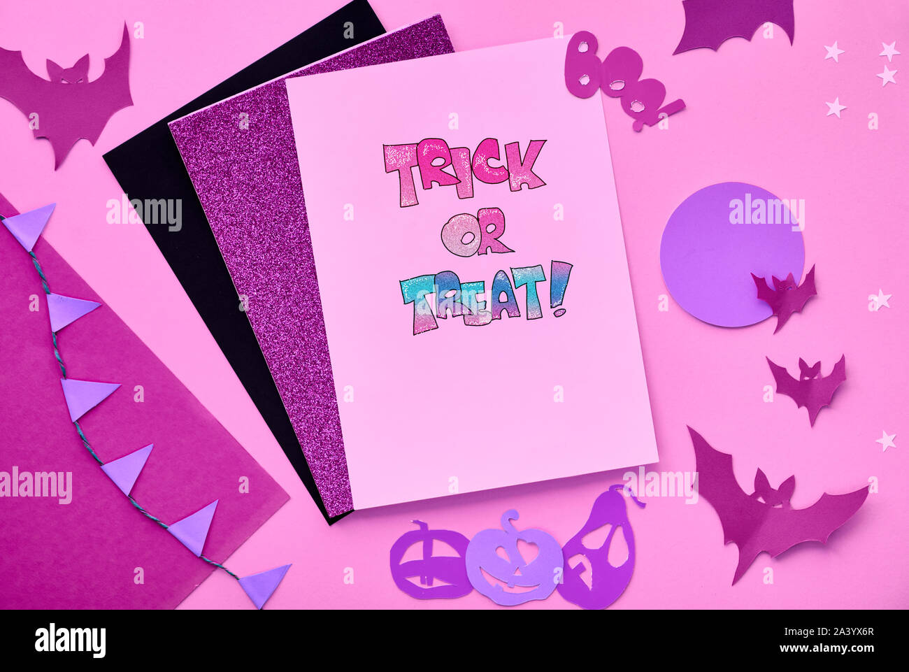 Creative carta artigianale Halloween laici piatta in rosa, viola chiaro e nero. Vista da sopra con copy-spazio sulla pila di schede, pipistrelli, occhi di cioccolato e jack LAN Foto Stock