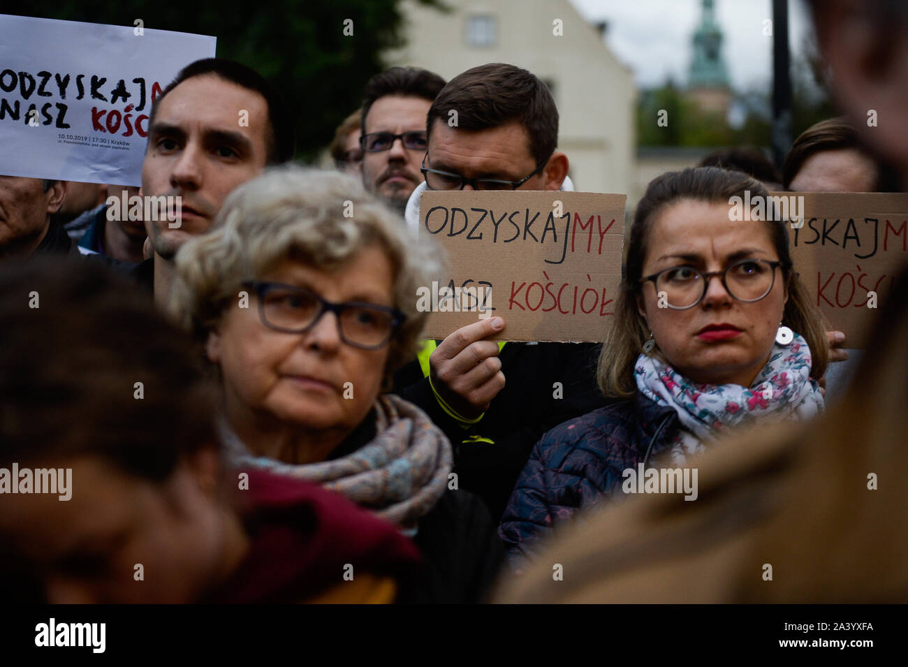 Cracovia in Polonia. 10 ottobre, 2019. Persone tengono cartelloni dicendo ' iniziamo la nostra chiesa back' durante la dimostrazione.la protesta contro la Polonia della cattolica Chiesa di recente di odio per condannare la comunità LGBT nella parte anteriore della finestra con il Papa Giovanni Paolo II opere d'arte. Negli ultimi mesi, il polacco della Chiesa cattolica è stata la chiamata del movimento LGBT il "rainbow peste". Prima delle elezioni politiche, la sentenza del governo, il diritto e la giustizia partito, ha condotto una campagna che il movimento LGBT è una caratteristica per il polacco valori della chiesa cattolica. Credito: SOPA Immagini limitata/Alamy Live News Foto Stock