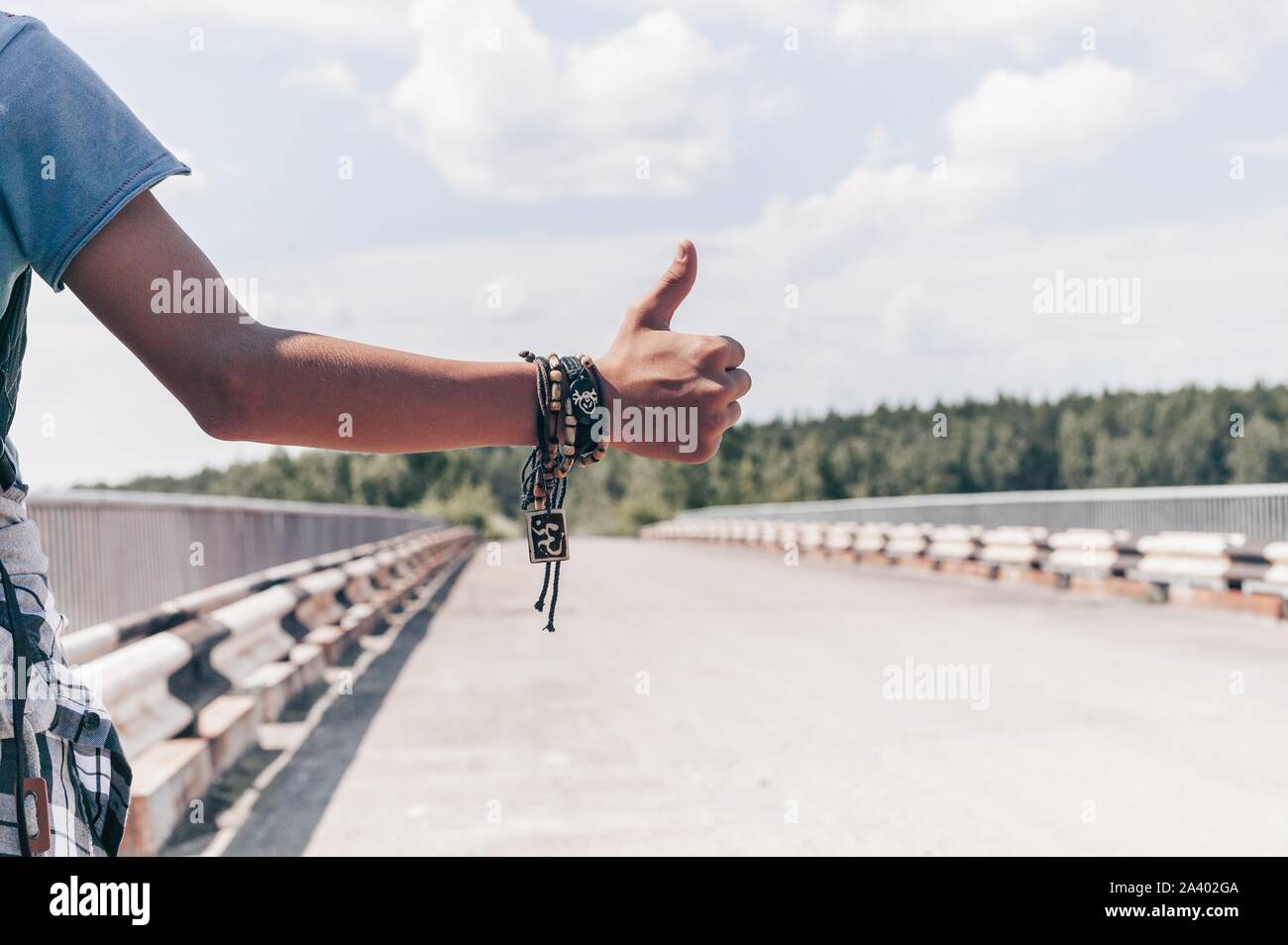 Mano Traveler autostop. Giovane ragazzo si arresta il passaggio di camion sull'autostrada. Autostop concept Foto Stock