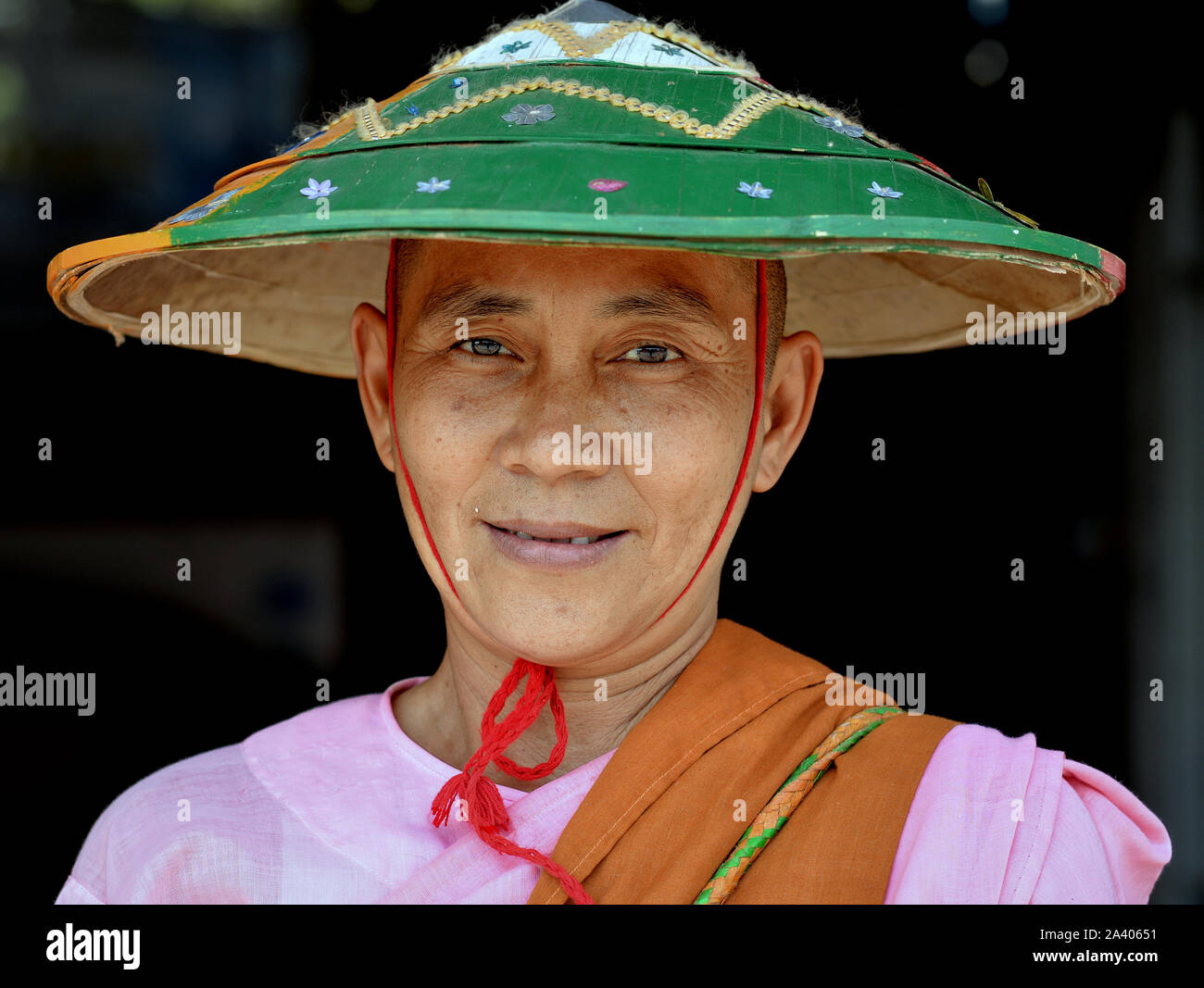 Buddista birmano nun indossa un verde, tradizionali asiatici cappello conico e sorrisi per la fotocamera. Foto Stock