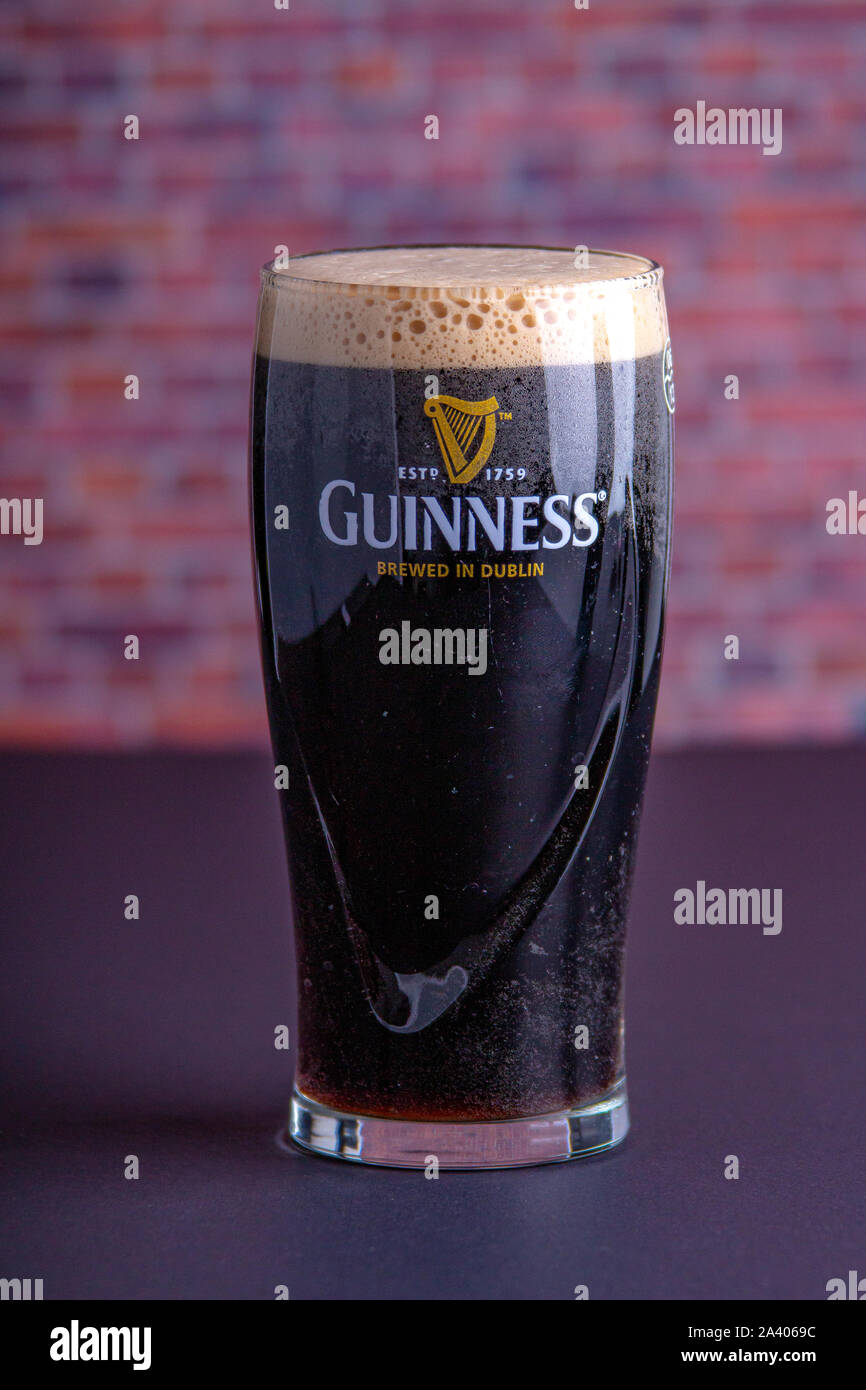 Una scura Guinness Irish Stout secca bicchiere di birra che ha origine nella fabbrica di birra a Dublino vista verticale Foto Stock