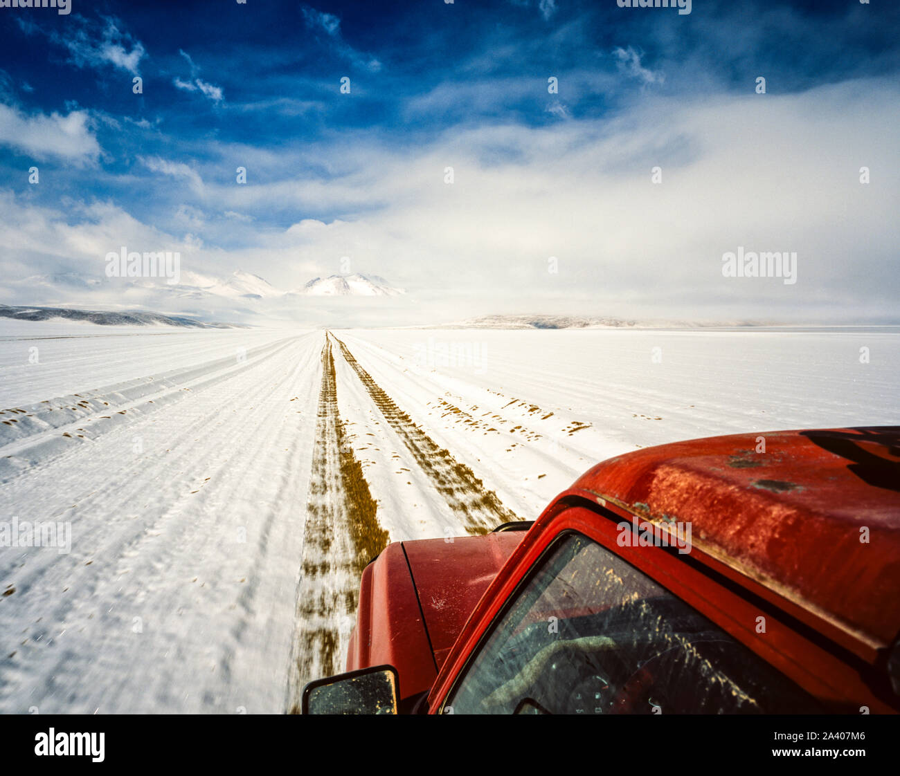 Red jeep percorrendo una coperta di neve sul percorso Altiplano in Bolivia Foto Stock