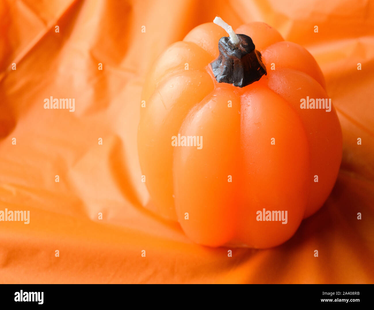 Arancio brillante candela zucca isolati su una tovaglia arancione sullo sfondo (blocco colore) Foto Stock