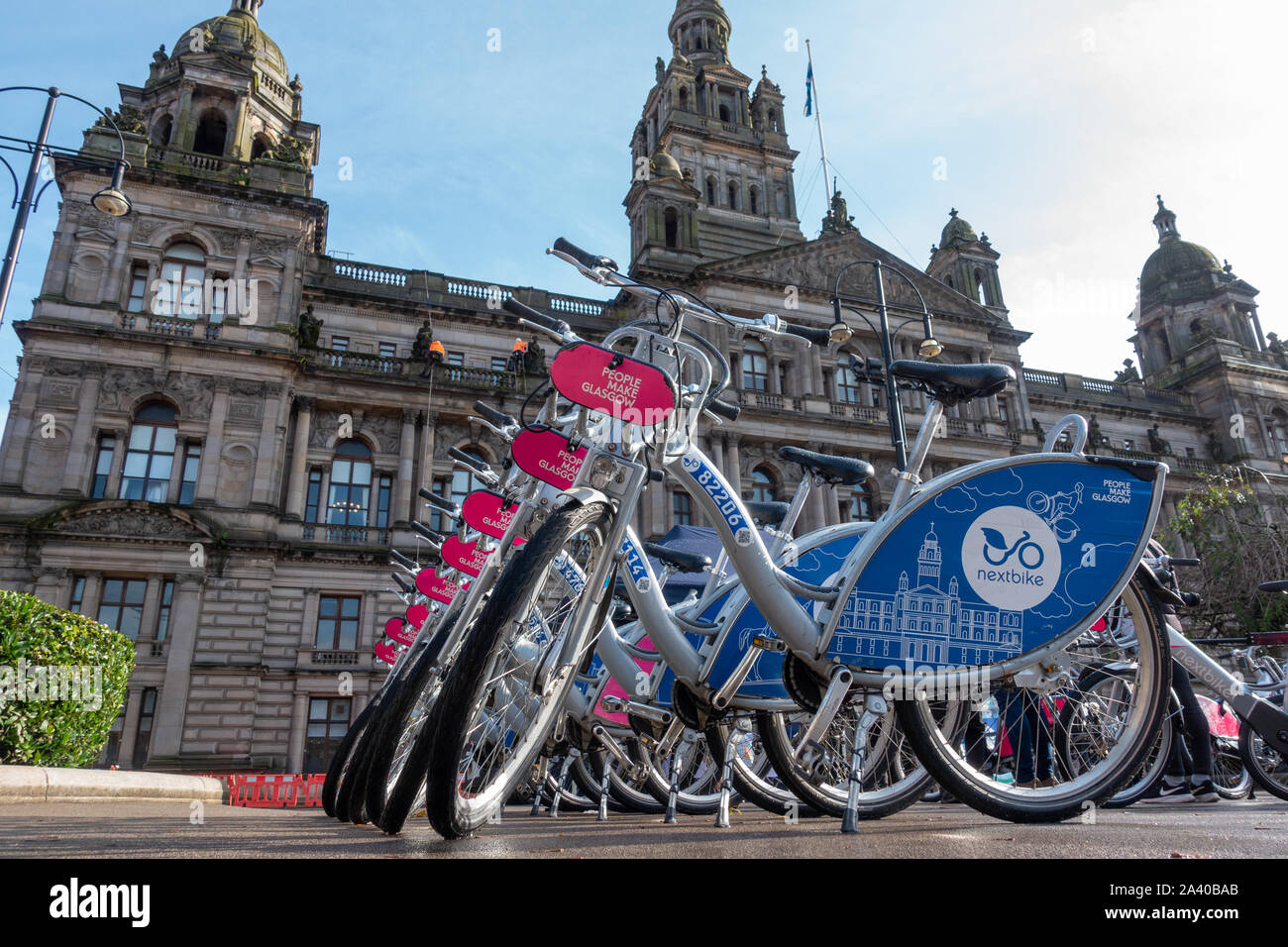 Biciclette a noleggio allineate di fronte alla City Chambers in George Square Glasgow come parte della promozione dell'e-bike. Foto Stock