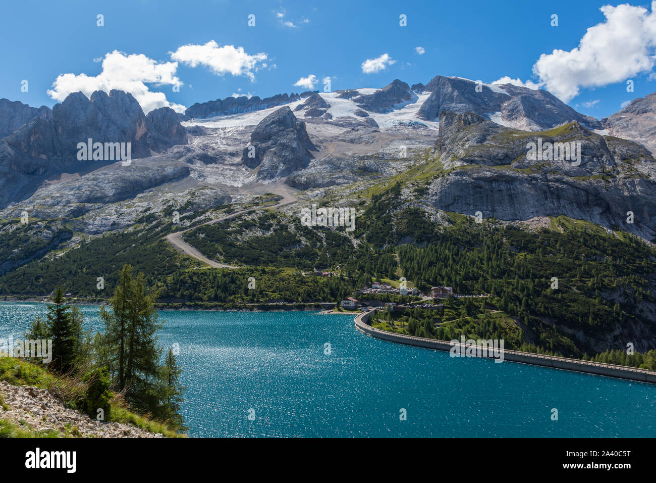 Il lago di Fedaia e Marmolada in montagna Dolomiti italiane, nuvoloso cielo blu Foto Stock