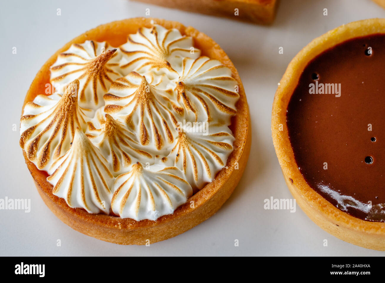 Mini limone crostata di meringa e cioccolato fondente tart. Vista dall'alto. Foto Stock