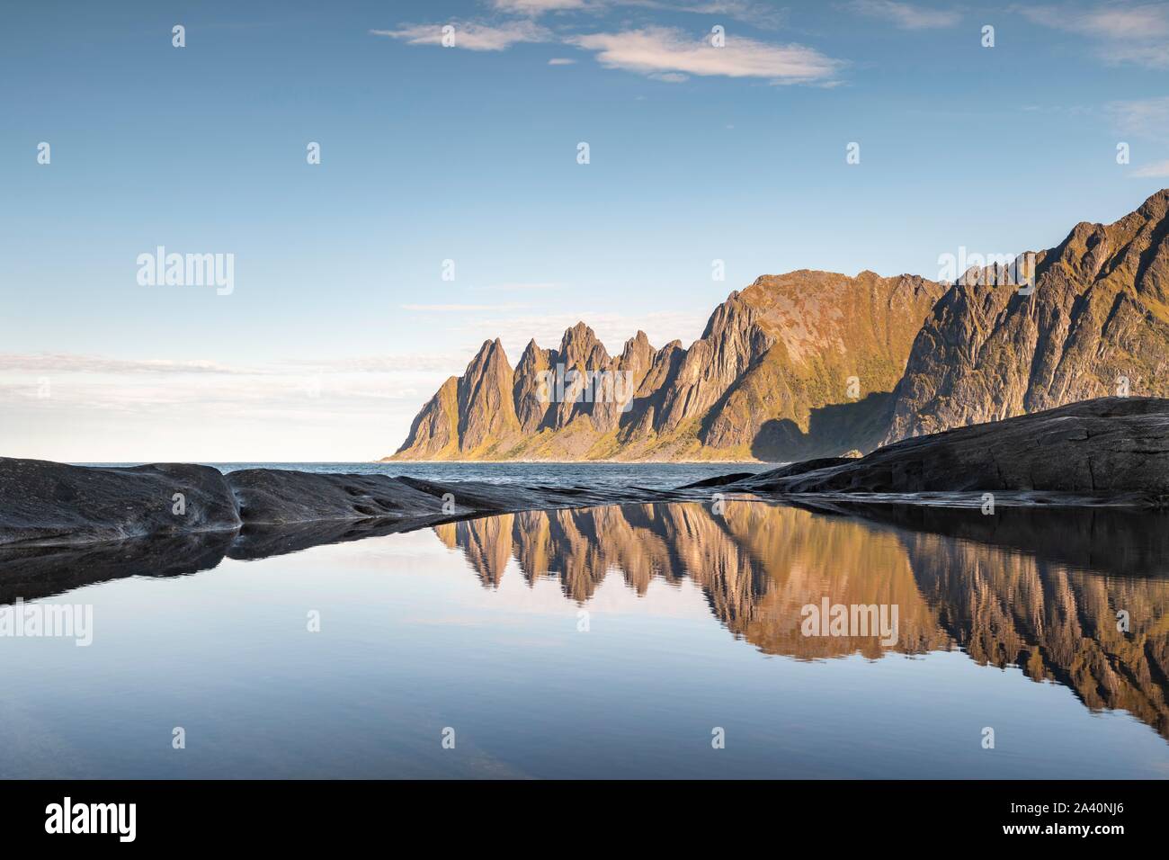 Picchi di montagna a Tungeneset riflessa nella piccola conca naturale, Devil's denti, Okshornan mountain range, Senja Isola, Troms, Norvegia Foto Stock