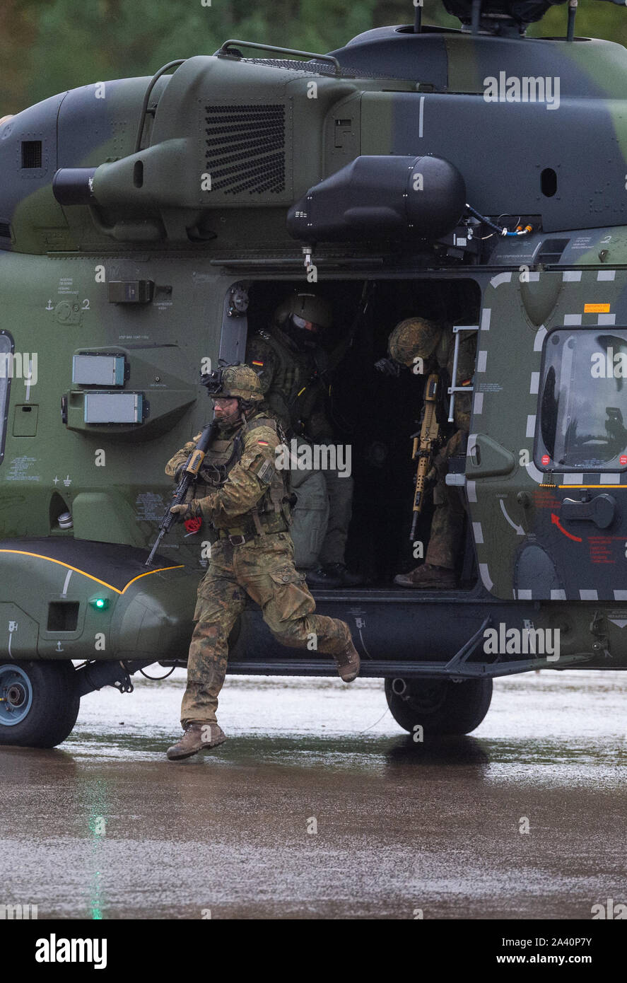 Munster, Germania. Undicesimo oct, 2019. Soldati della Bundeswehr lasciare un elicottero del tipo 'NH90' durante la formazione Informazioni di esercizio delle operazioni di Terra 2019. Durante la formazione Informazioni di esercizio delle operazioni di Terra 2019 della Bundeswehr, l'esercito, il servizio medico e il cyber forze di dimostrare le loro capacità davanti al pubblico di casa e all'estero. Credito: Philipp Schulze/dpa/Alamy Live News Foto Stock