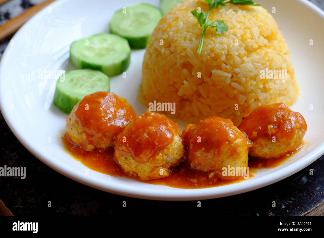 Piatto di riso vegano vietnamita con polpette di palla tofu, salsa di pomodoro, cetrioli per pranzo vegetariano, delizioso in casa, cibo sano vegetale Foto Stock
