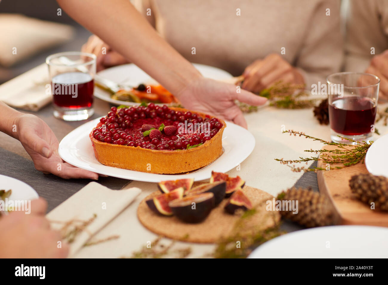 Close-up di donna mettendo berry torta dolce sul tavolo per il dessert dopo il corso principale Foto Stock