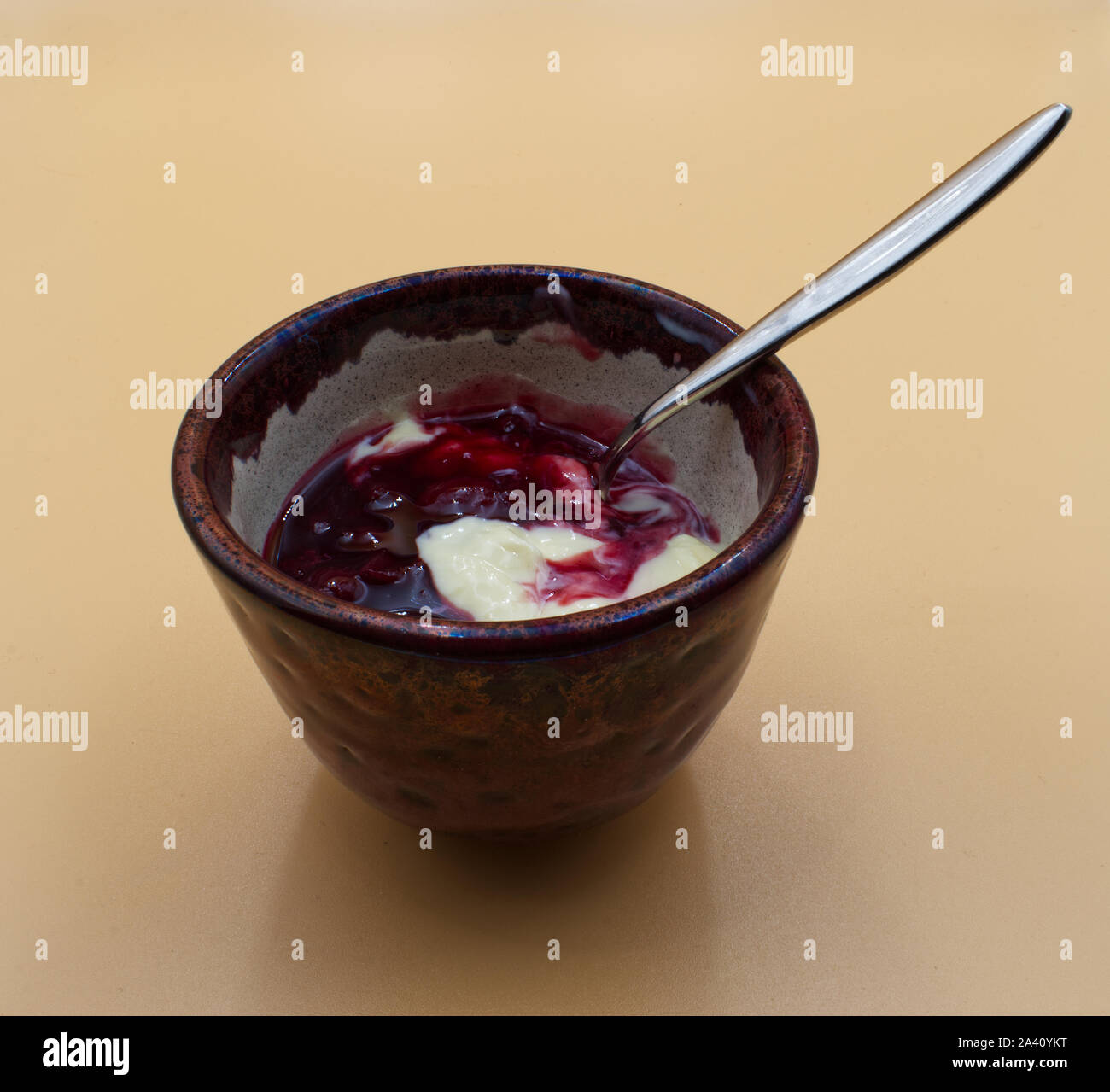 Yogurt alla vaniglia e amarene in una tazza marrone Foto Stock