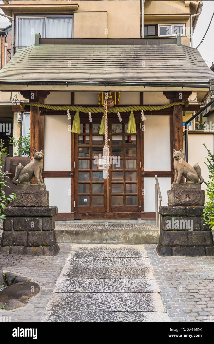 Due statue di volpi inari, divinità del riso nel sacrario scintoista di Mejiro Toyosaka Inari Jinja in Tokyo. Foto Stock