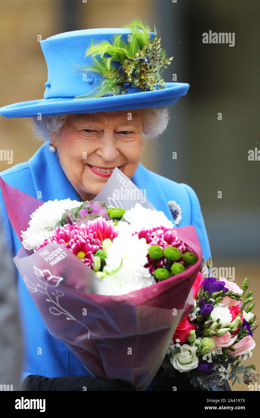 Queen Elizabeth II riceve mazzi di fiori durante la sua visita a Haig alloggiamento fiducia, Morden, Londra, dove lei si aprirà ufficialmente il loro nuovo sviluppo di alloggiamento per le forze armate di veterani e l'ex-community del servizio. Foto Stock