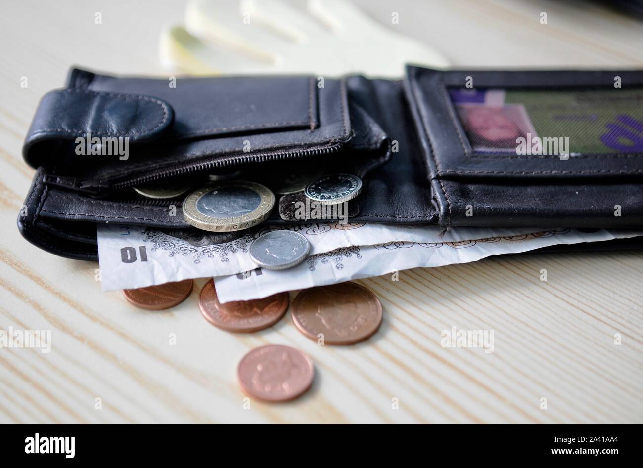 Giovane di portafoglio con Sterline monete e banconote. Foto Stock